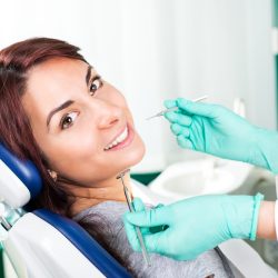 Smiling woman at dentist sitting in dentist chair ready for a dental check-up.